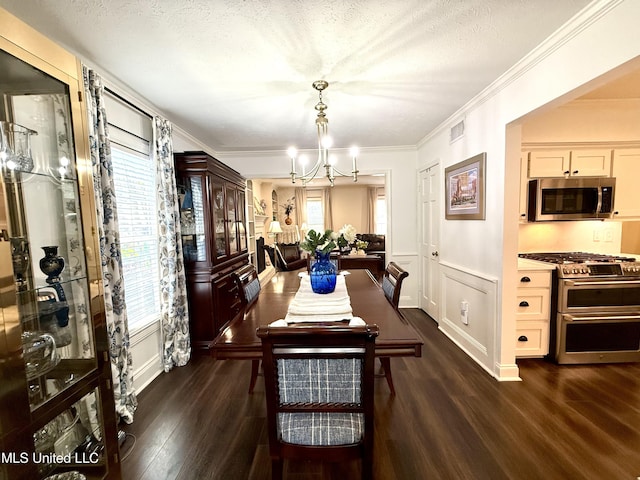 dining space with a chandelier, dark wood-style floors, crown molding, and baseboards