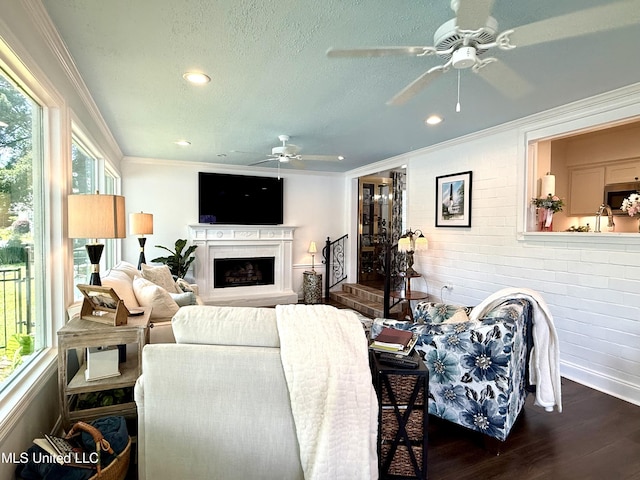 living room with ceiling fan, dark wood-style flooring, recessed lighting, a fireplace with raised hearth, and a textured ceiling