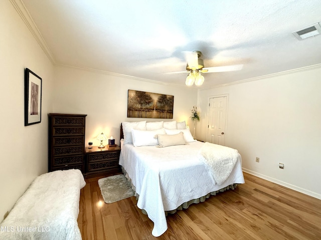 bedroom featuring ornamental molding, wood finished floors, ceiling fan, and baseboards