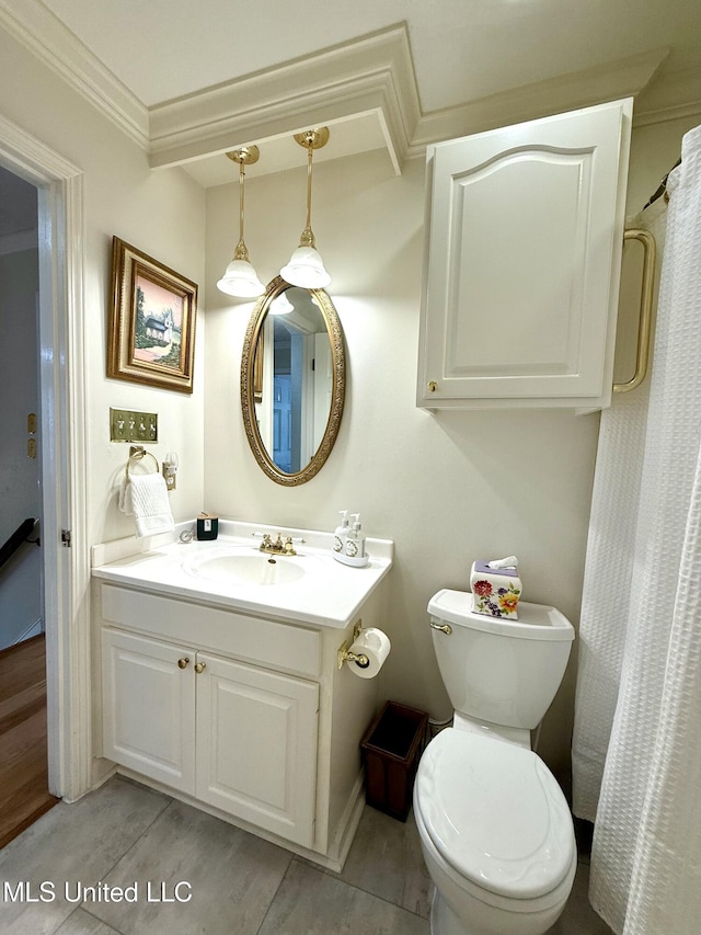 bathroom with wood finished floors, vanity, toilet, and crown molding