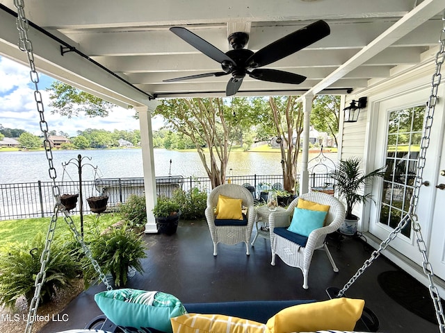 sunroom featuring a ceiling fan and a water view