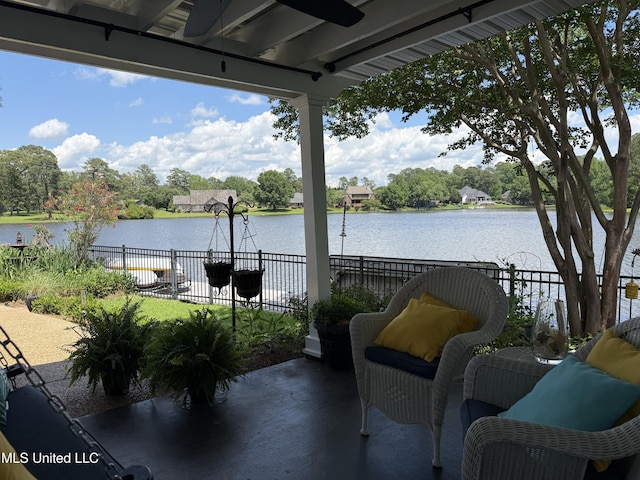 view of patio / terrace featuring a water view, fence, and ceiling fan