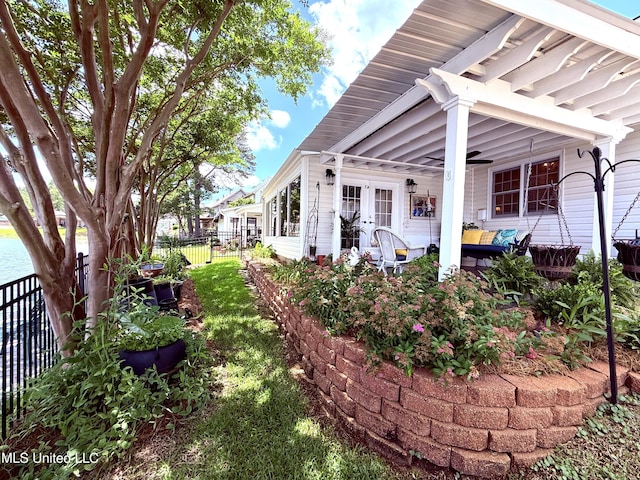 view of side of property with fence and a ceiling fan