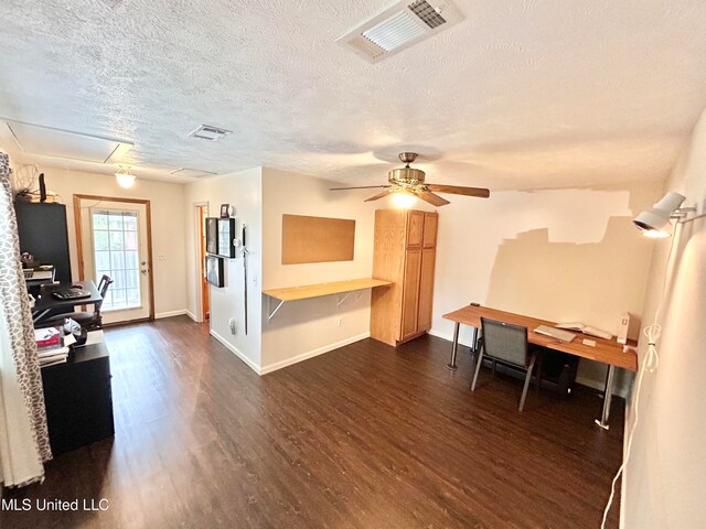 interior space with a textured ceiling, dark hardwood / wood-style floors, and ceiling fan