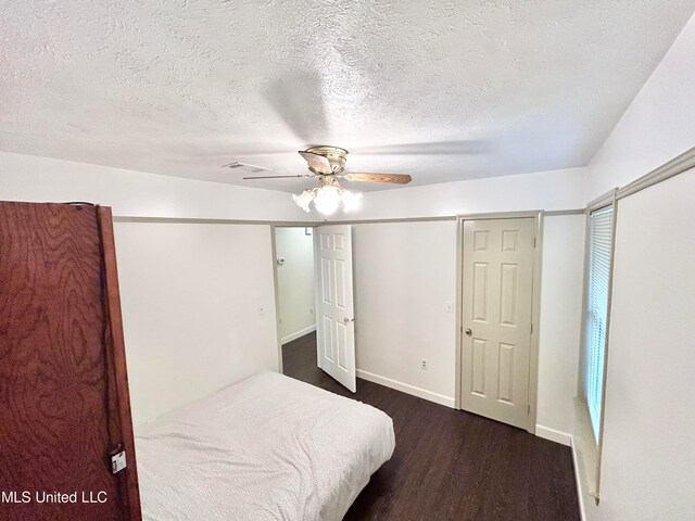 bedroom featuring ceiling fan, a textured ceiling, and dark hardwood / wood-style floors