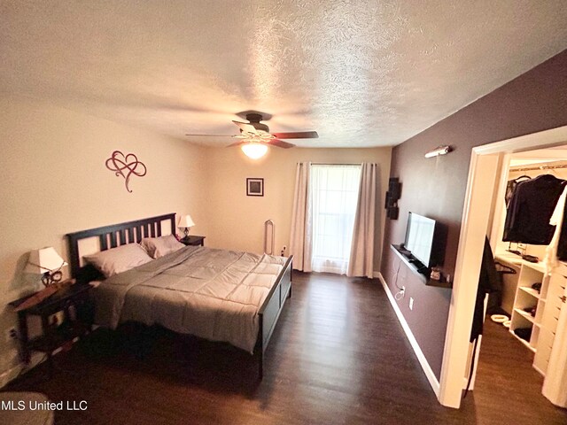 bedroom featuring dark hardwood / wood-style floors, a textured ceiling, and ceiling fan