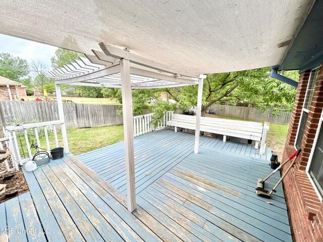 wooden deck with a lawn and a pergola