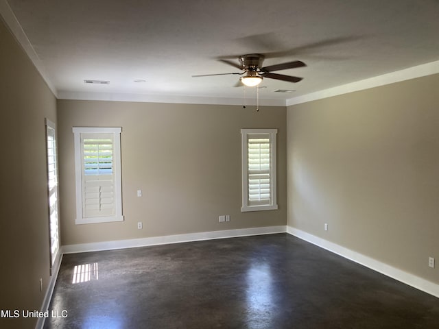 unfurnished room with a ceiling fan, healthy amount of natural light, concrete flooring, baseboards, and crown molding