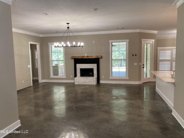 unfurnished living room featuring concrete flooring, baseboards, a chandelier, a fireplace with raised hearth, and ornamental molding