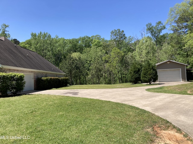 view of green lawn with an outbuilding and a detached garage