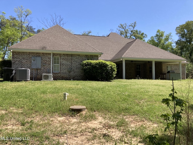 back of house with central AC unit, a yard, ceiling fan, and a shingled roof