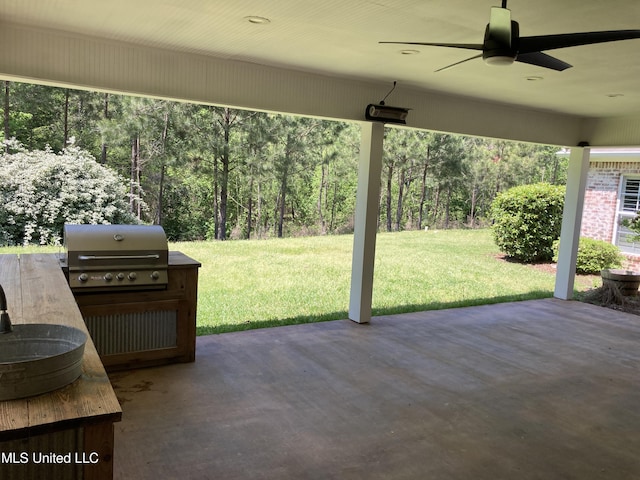 view of patio / terrace featuring a grill, a ceiling fan, and a wooded view