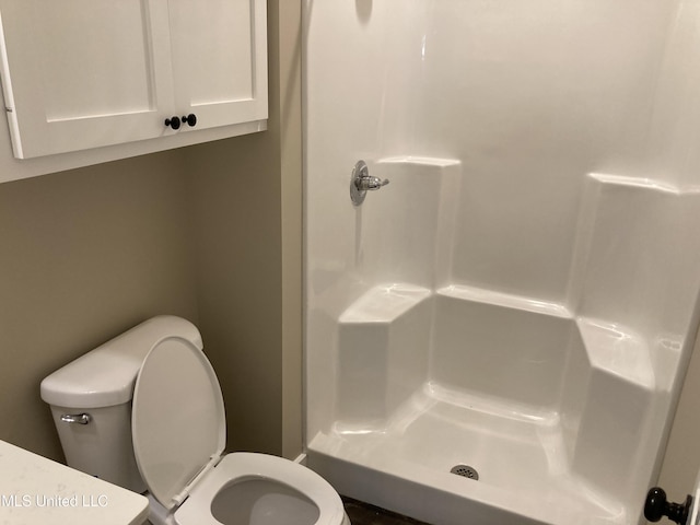 full bathroom with a shower stall and toilet