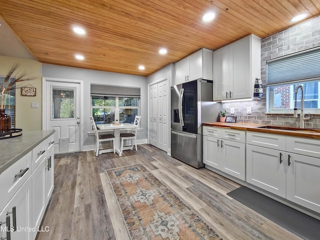 881 Brentwood Dr, Biloxi, MS 39532 - kitchen with stainless steel fridge with ice dispenser, wooden ceiling, butcher block counters, light wood-type flooring, and white cabinets