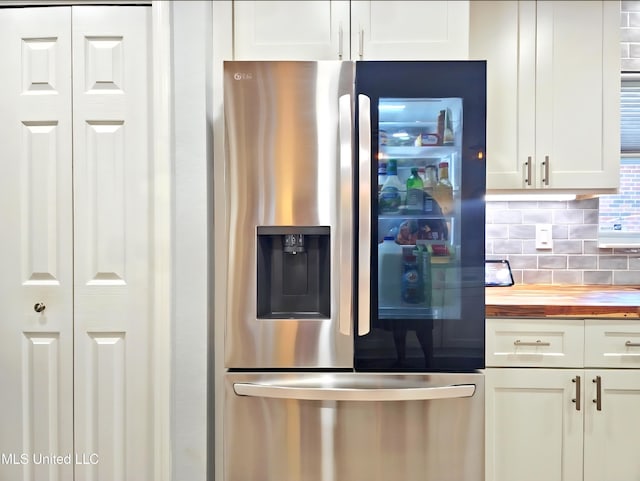881 Brentwood Dr, Biloxi, MS 39532 - kitchen featuring stainless steel fridge, wood counters, decorative backsplash, and white cabinets