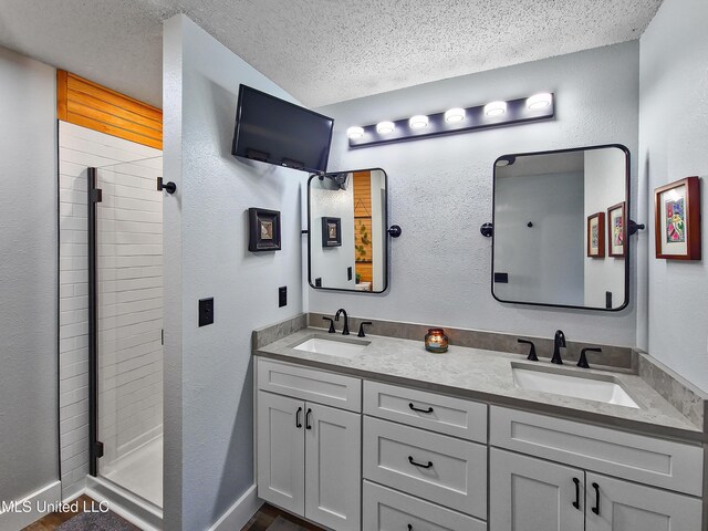 881 Brentwood Dr, Biloxi, MS 39532 - bathroom with a textured ceiling, double vanity, and a stall shower