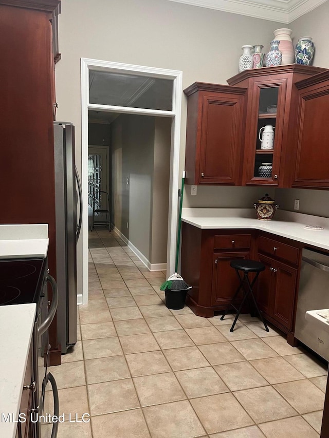 kitchen with light tile patterned floors, stainless steel appliances, and ornamental molding