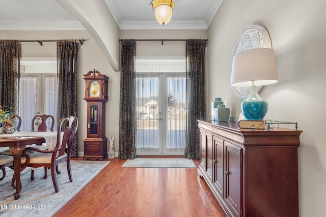 interior space with wood-type flooring, crown molding, and french doors