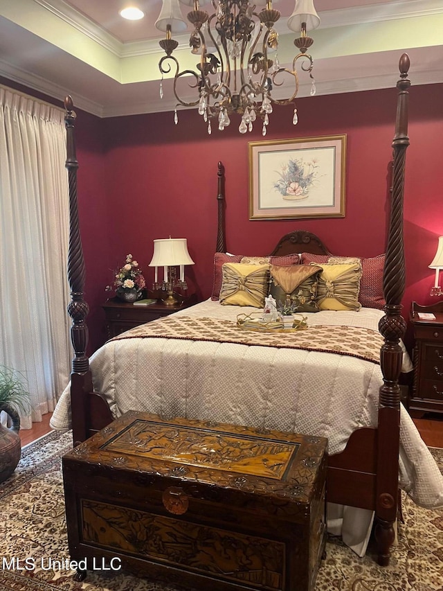 bedroom with a chandelier, wood-type flooring, ornamental molding, and a tray ceiling