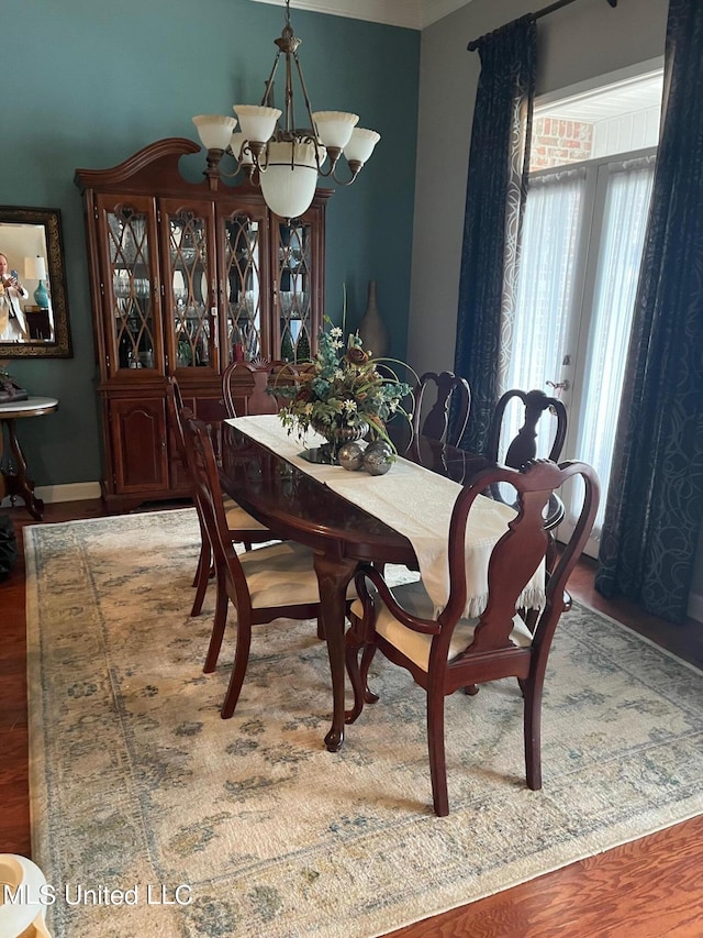 dining space with hardwood / wood-style flooring, french doors, and an inviting chandelier