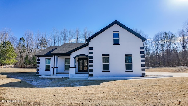 view of front facade with a front lawn and french doors