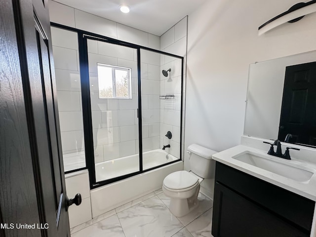 full bathroom with enclosed tub / shower combo, vanity, and toilet