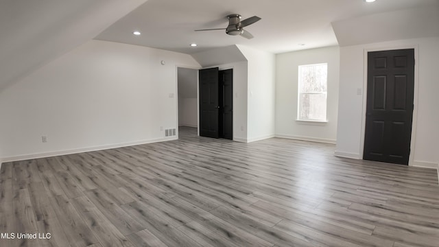 spare room featuring lofted ceiling, light hardwood / wood-style floors, and ceiling fan