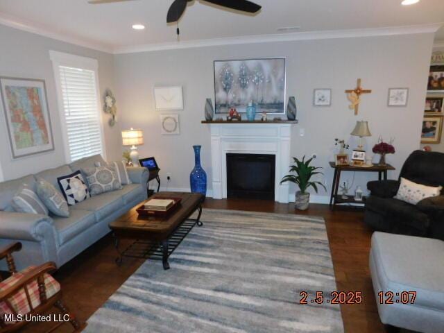 living room with dark hardwood / wood-style flooring, crown molding, and ceiling fan