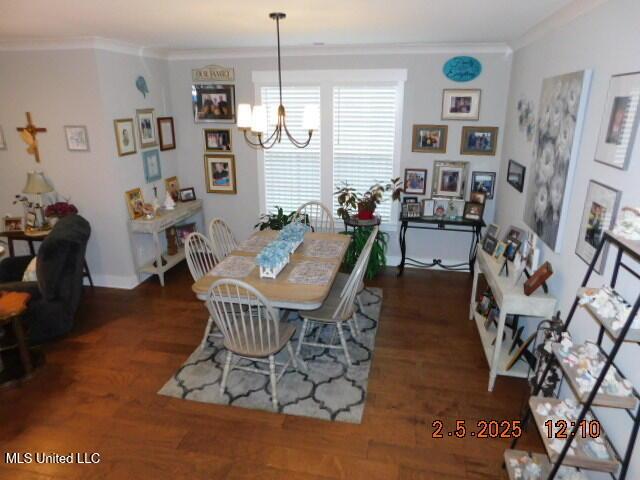 dining room with ornamental molding, dark hardwood / wood-style floors, and a chandelier