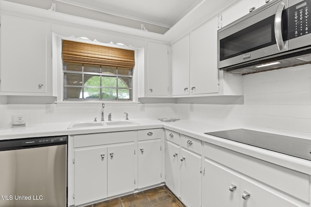 kitchen with a sink, light countertops, tasteful backsplash, and appliances with stainless steel finishes