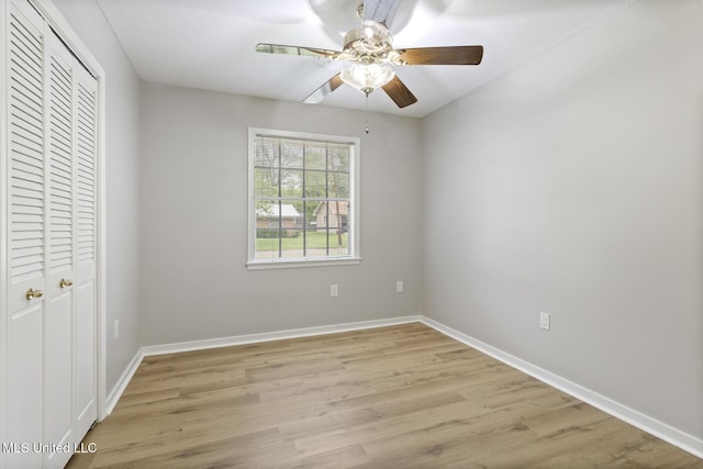 unfurnished bedroom with a closet, baseboards, light wood finished floors, and a ceiling fan