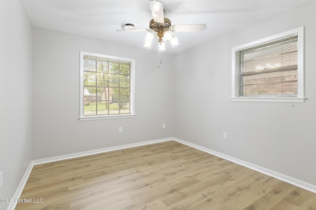 empty room featuring baseboards, light wood finished floors, and a ceiling fan