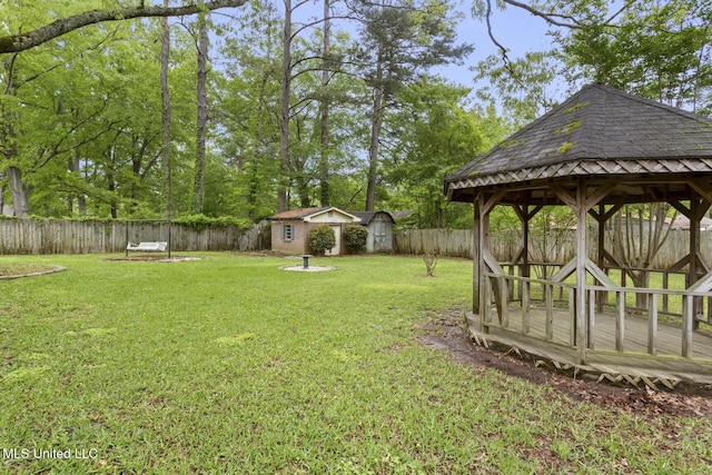 view of yard featuring an outbuilding, a fenced backyard, a gazebo, and a shed