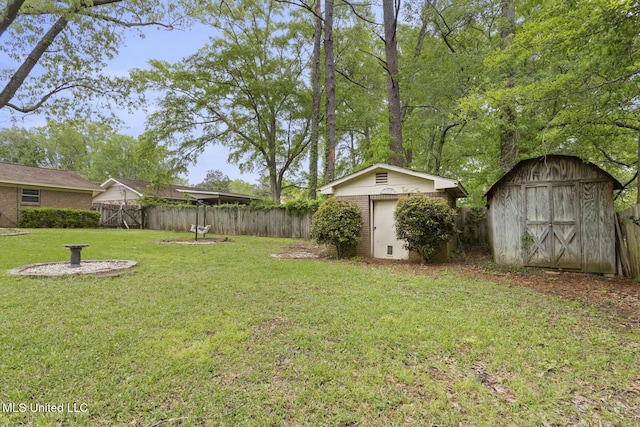 view of yard with a storage shed, fence, and an outbuilding