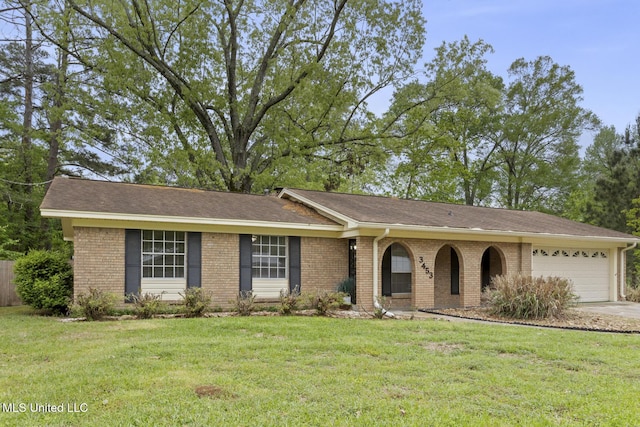 ranch-style home with a front yard, brick siding, driveway, and an attached garage
