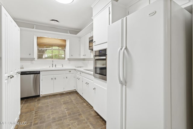 kitchen featuring a sink, light countertops, appliances with stainless steel finishes, and white cabinets