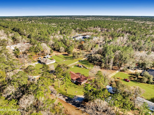 bird's eye view with a wooded view