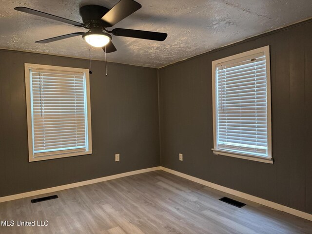 217 S Sunset Ter, Jackson, MS 39212 - unfurnished room with a textured ceiling, light hardwood / wood-style flooring, and a healthy amount of sunlight