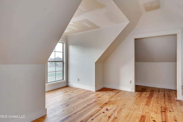 bonus room featuring lofted ceiling and light hardwood / wood-style floors