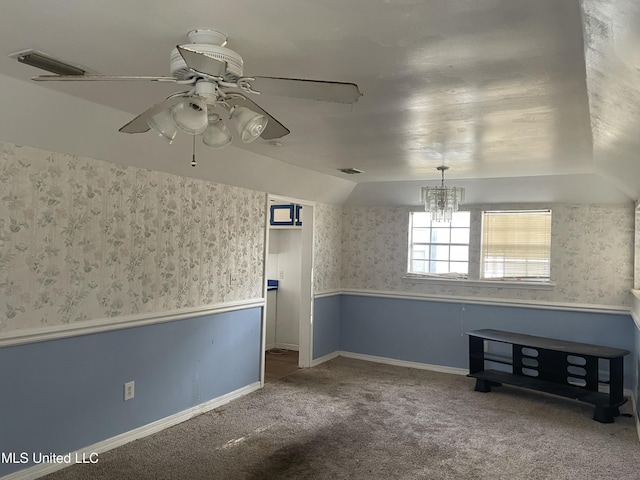 carpeted spare room with lofted ceiling and ceiling fan with notable chandelier