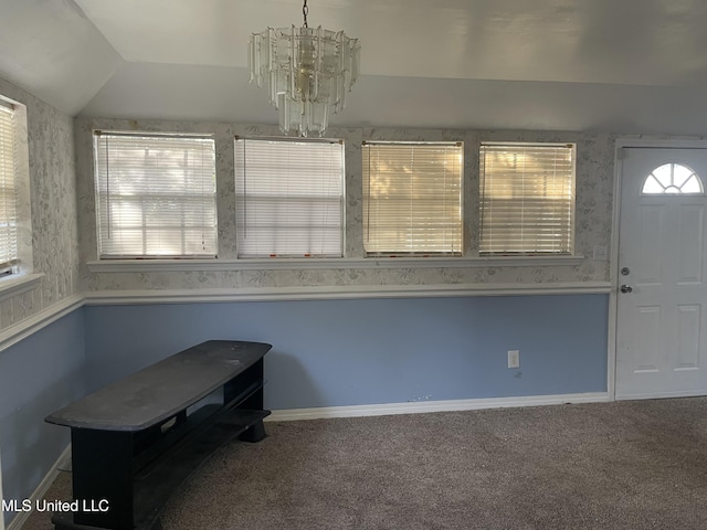 interior space featuring a notable chandelier, carpet, and lofted ceiling