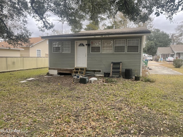 back of house featuring central AC unit and a lawn