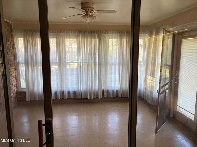 unfurnished sunroom with tile patterned floors and ornamental molding