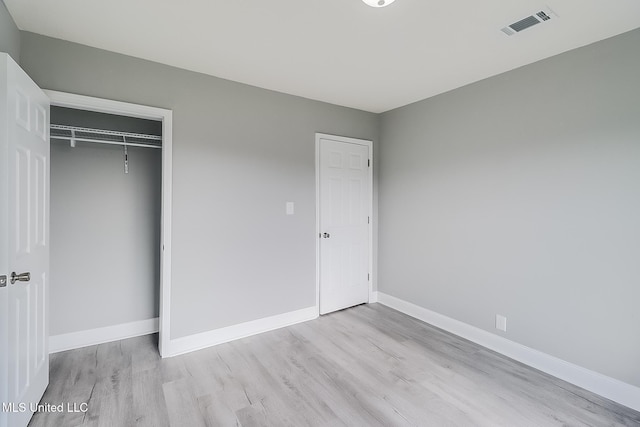 unfurnished bedroom with a closet and light wood-type flooring