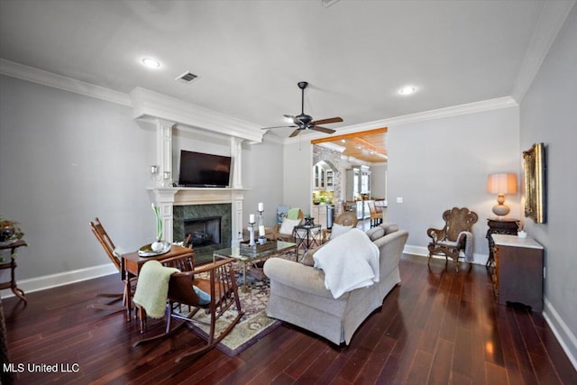 living room with crown molding, dark hardwood / wood-style floors, ceiling fan, and a high end fireplace