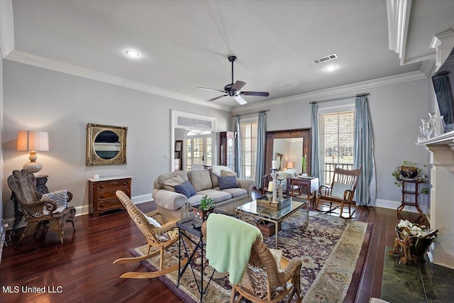 living room with crown molding, dark wood-type flooring, a fireplace, and ceiling fan