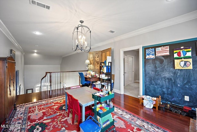 playroom with wood-type flooring, ornamental molding, and an inviting chandelier