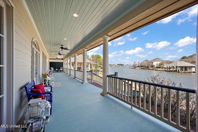 balcony featuring a water view and ceiling fan