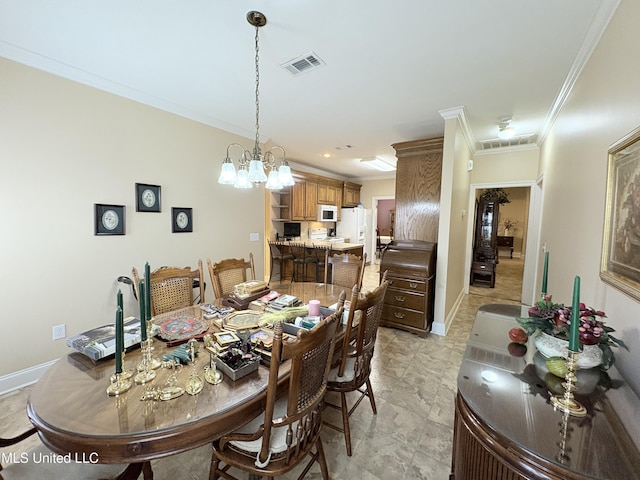 dining space featuring visible vents, crown molding, baseboards, and an inviting chandelier