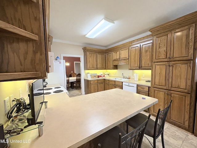 kitchen featuring white appliances, a peninsula, light countertops, crown molding, and a sink